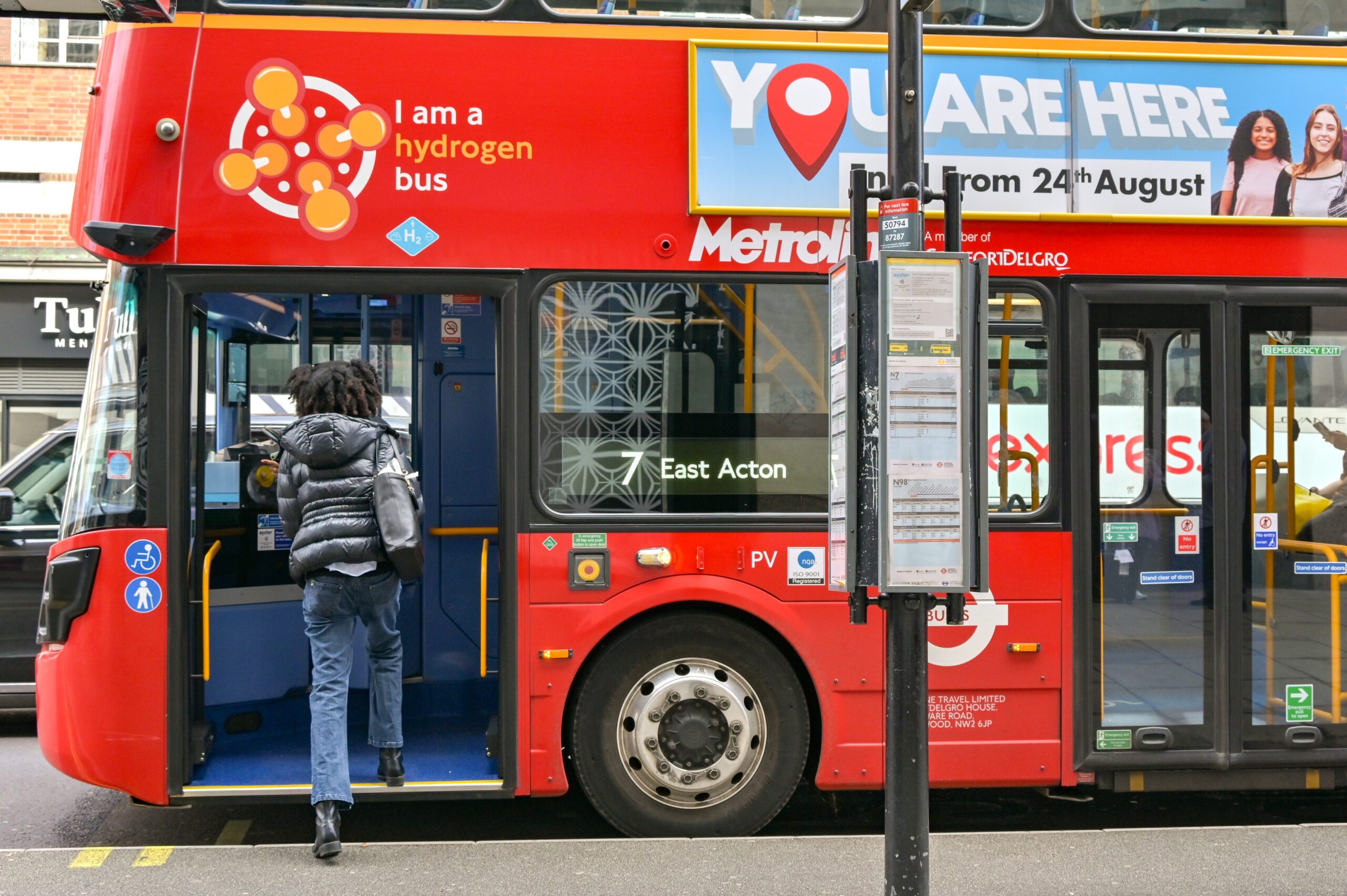 A young woman boarding a London bus